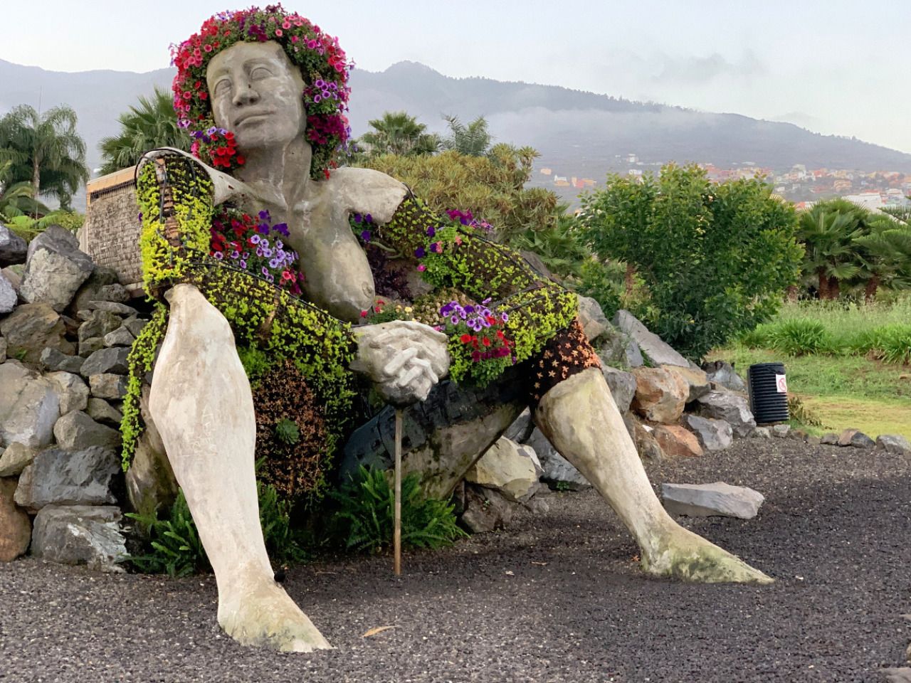 Steinstatue von einer Frau mit Blumen umwachsen in Teneriffa, Spanien